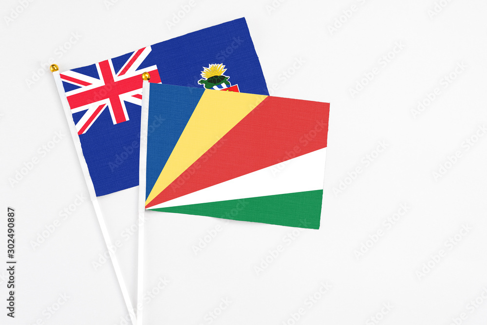 Seychelles and Cayman Islands stick flags on white background. High quality fabric, miniature national flag. Peaceful global concept.White floor for copy space. Seychelles and Cayman Islands stick flags on white background. High quality fabric, miniature national flag. Peaceful global concept.White floor for copy space.