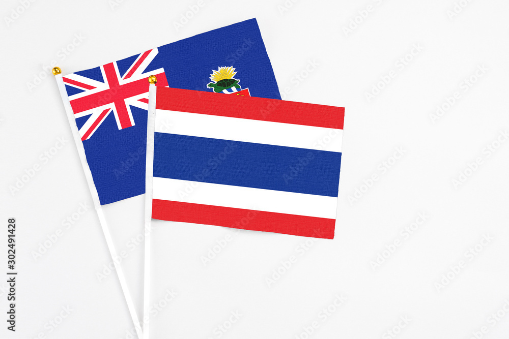 Thailand and Cayman Islands stick flags on white background. High quality fabric, miniature national flag. Peaceful global concept.White floor for copy space. Thailand and Cayman Islands stick flags on white background. High quality fabric, miniature national flag. Peaceful global concept.White floor for copy space.
