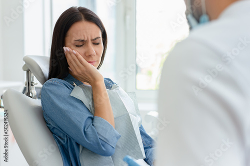 attractive woman with pain in dentist office with doctor