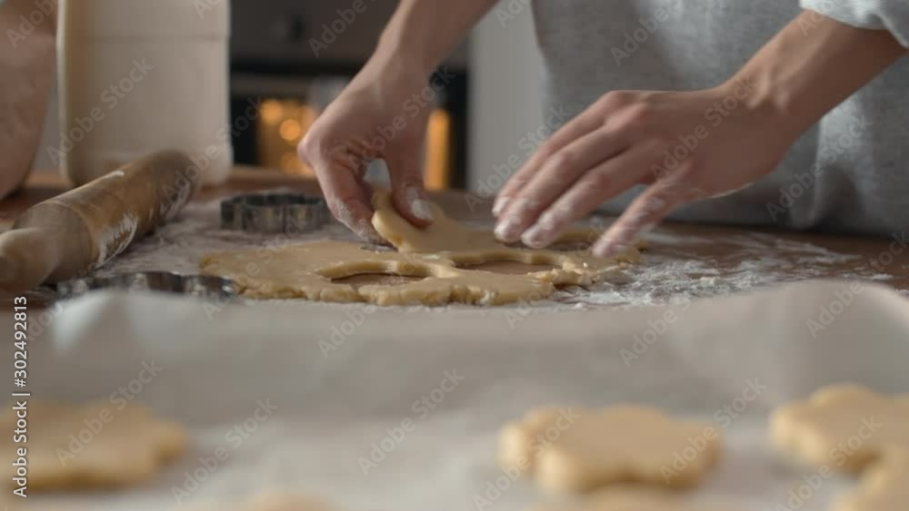 Close up of housewife hands making biscuits in shape of flower using steel baking tin Close up of housewife hands making biscuits in shape of flower using steel baking tin