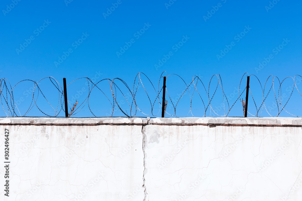 Jail wall. Highly protected prison wall with barbed wire fence Jail wall. Highly protected prison wall with barbed wire fence