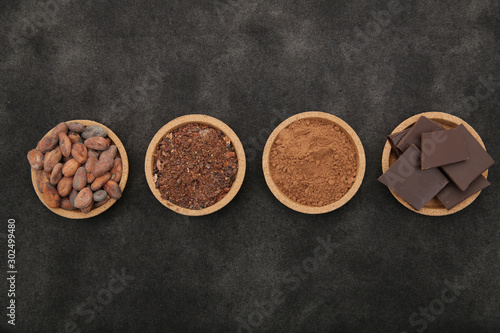 organic cacao beans, cocoa powder, ground and chocolate on a black background with copy space for text. Flat lay, top view. Ingredient. Vegan food. Background, pattern, card, menu. 