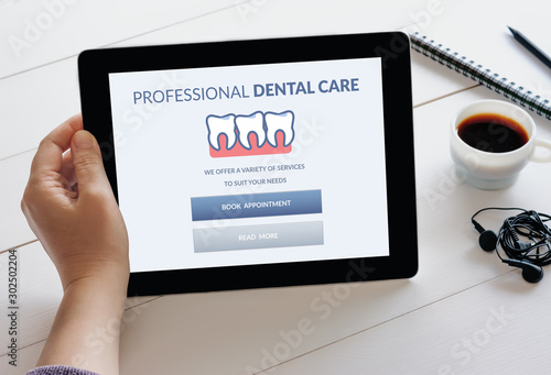 Hand holding tablet with dental care concept on screen