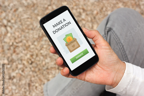 фотографія Hand holding smart phone with donate concept on screen
