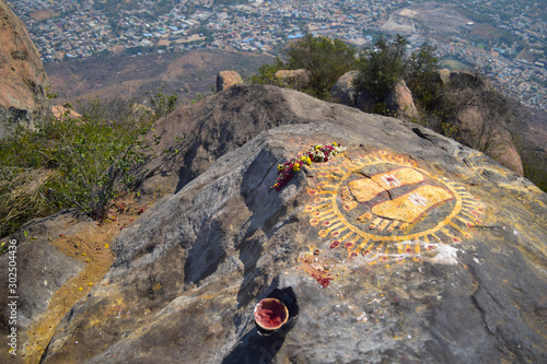 Feet symbol at the top view of Tiruvannamalai city and Arunacheshvara Temple from Arunachala hill with two travellers going down, Tamil Nadu India