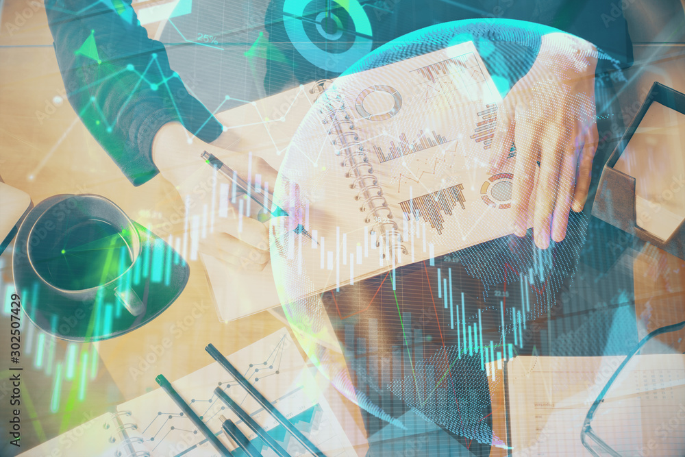 Double exposure of hands making notes with forex chart huds. Stock market concept. Double exposure of hands making notes with forex chart huds. Stock market concept.