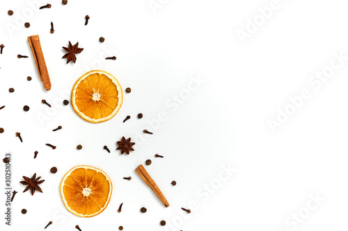 Christmas composition made of dried orange, cinnamon, black pepper, star anice and clove on white background. Top view, copy space. Set of spices for mulled wine.