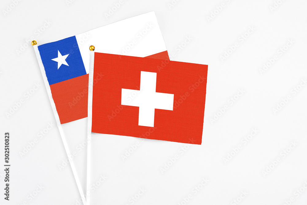 Switzerland and Chile stick flags on white background. High quality fabric, miniature national flag. Peaceful global concept.White floor for copy space.