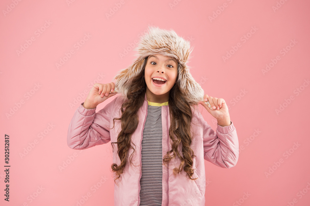 Warm smile. happy child pink background. warm clothes for cold season. kid fashion. trendy girl look like hipster. autumn style. Childhood activity. fur earflap hat accessory. small girl winter hat Warm smile. happy child pink background. warm clothes for cold season. kid fashion. trendy girl look like hipster. autumn style. Childhood activity. fur earflap hat accessory. small girl winter hat