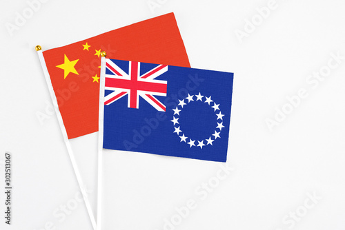 Cook Islands and China stick flags on white background. High quality fabric, miniature national flag. Peaceful global concept.White floor for copy space.