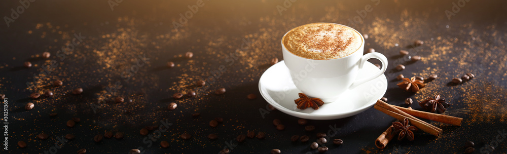 White cup with coffee on a black background, top view. Coffee with cinnamon. Long banner with copy space. Macro photo. - obrazy, fototapety, plakaty 