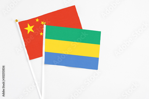 Gabon and China stick flags on white background. High quality fabric  miniature national flag. Peaceful global concept.White floor for copy space.