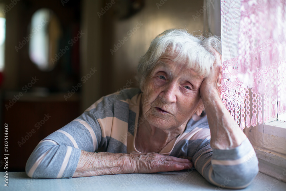 Portrait of a pensioner woman at the table in home. Portrait of a pensioner woman at the table in home.