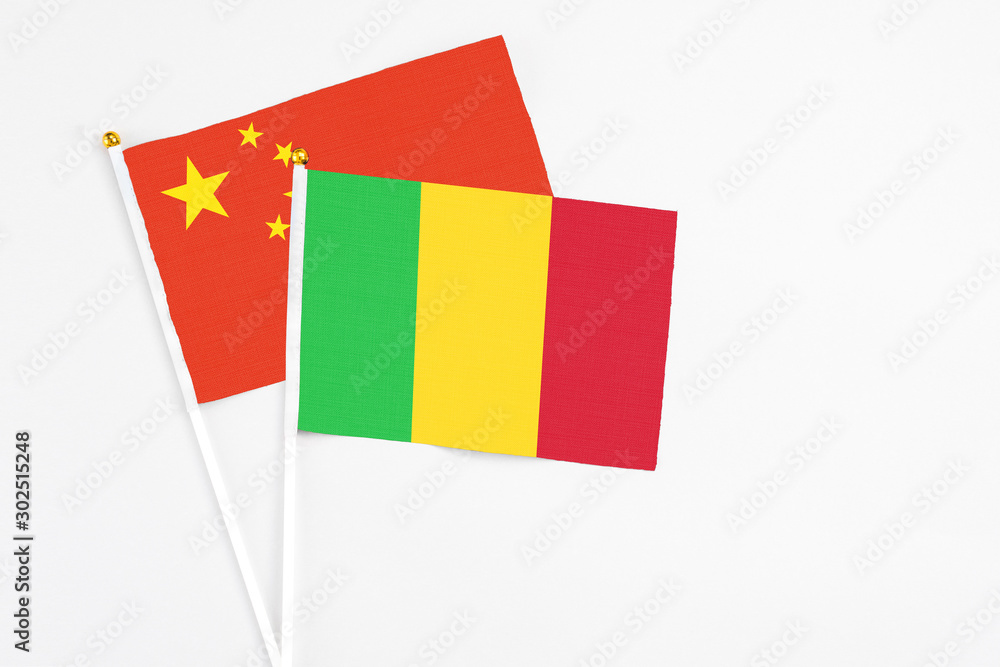 Mali and China stick flags on white background. High quality fabric, miniature national flag. Peaceful global concept.White floor for copy space. Mali and China stick flags on white background. High quality fabric, miniature national flag. Peaceful global concept.White floor for copy space.