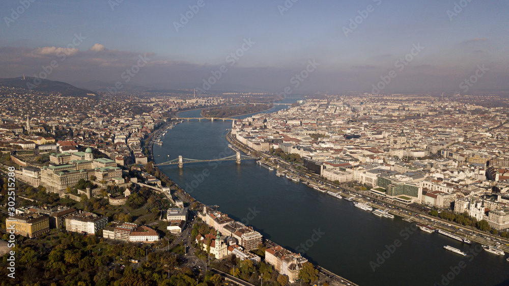 The highest point of Budapest with a view of the city panorama. A river with bridges and ships. Sunset sun. Chain bridge, palace and parliament. Top view.