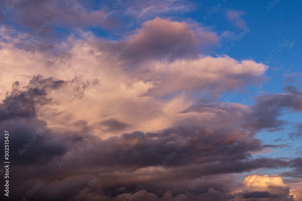 Dramatic colorful cumulus stormclouds at sunset sky, heaven