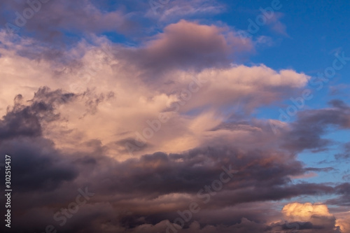 Dramatic colorful cumulus stormclouds at sunset sky, heaven