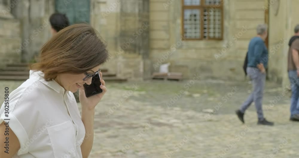 Mature beautiful woman walking and talking on smartphone Mature beautiful woman walking and talking on smartphone