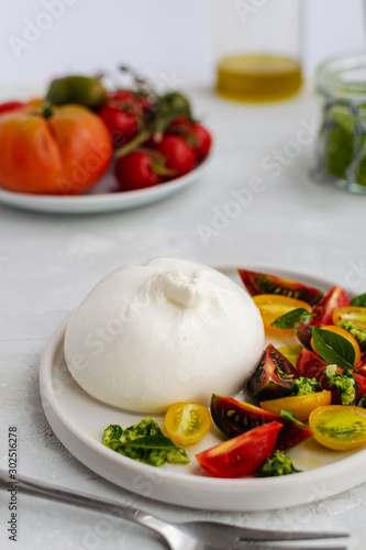 Salad with italian burrata cheese, fresh ripe tomatoes and basil