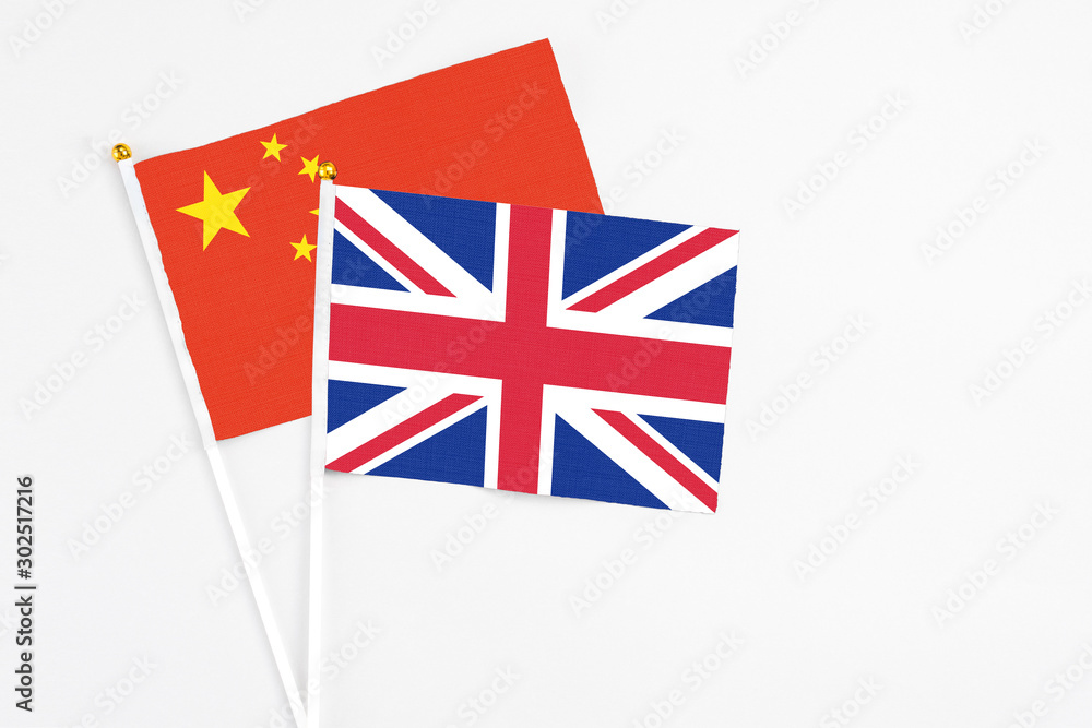United Kingdom and China stick flags on white background. High quality fabric, miniature national flag. Peaceful global concept.White floor for copy space. United Kingdom and China stick flags on white background. High quality fabric, miniature national flag. Peaceful global concept.White floor for copy space.