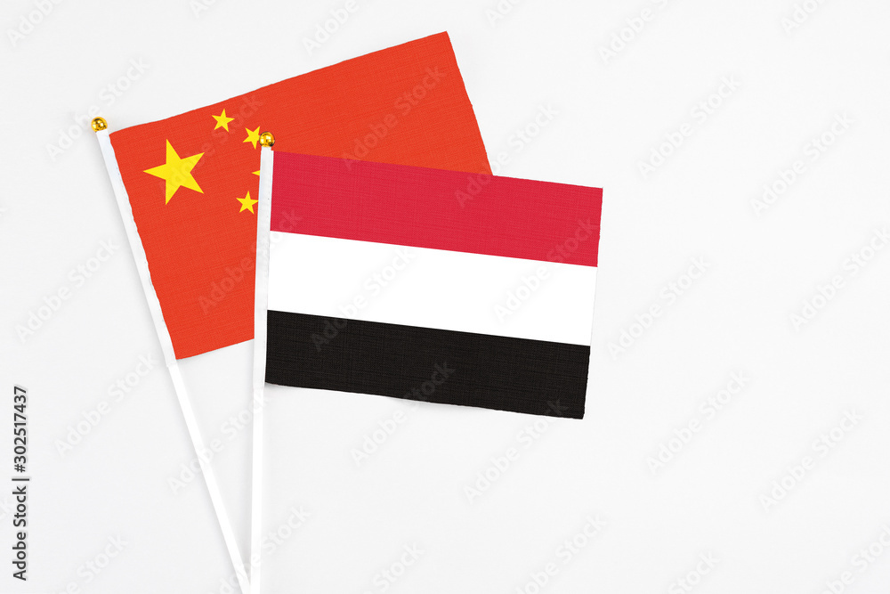 Yemen and China stick flags on white background. High quality fabric, miniature national flag. Peaceful global concept.White floor for copy space. Yemen and China stick flags on white background. High quality fabric, miniature national flag. Peaceful global concept.White floor for copy space.