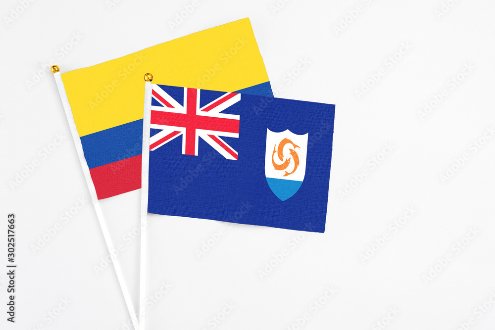 Anguilla and Colombia stick flags on white background. High quality fabric, miniature national flag. Peaceful global concept.White floor for copy space. Anguilla and Colombia stick flags on white background. High quality fabric, miniature national flag. Peaceful global concept.White floor for copy space.