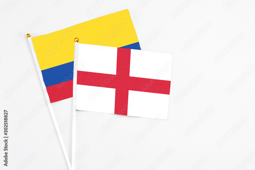 England and Colombia stick flags on white background. High quality fabric, miniature national flag. Peaceful global concept.White floor for copy space.