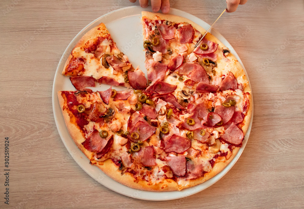 photo of pizza from which a piece is cut. Top view photo of pizza from which a piece is cut. Top view