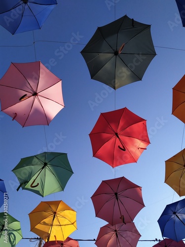 Background design  street decor. Multi-colored umbrellas against the sky.