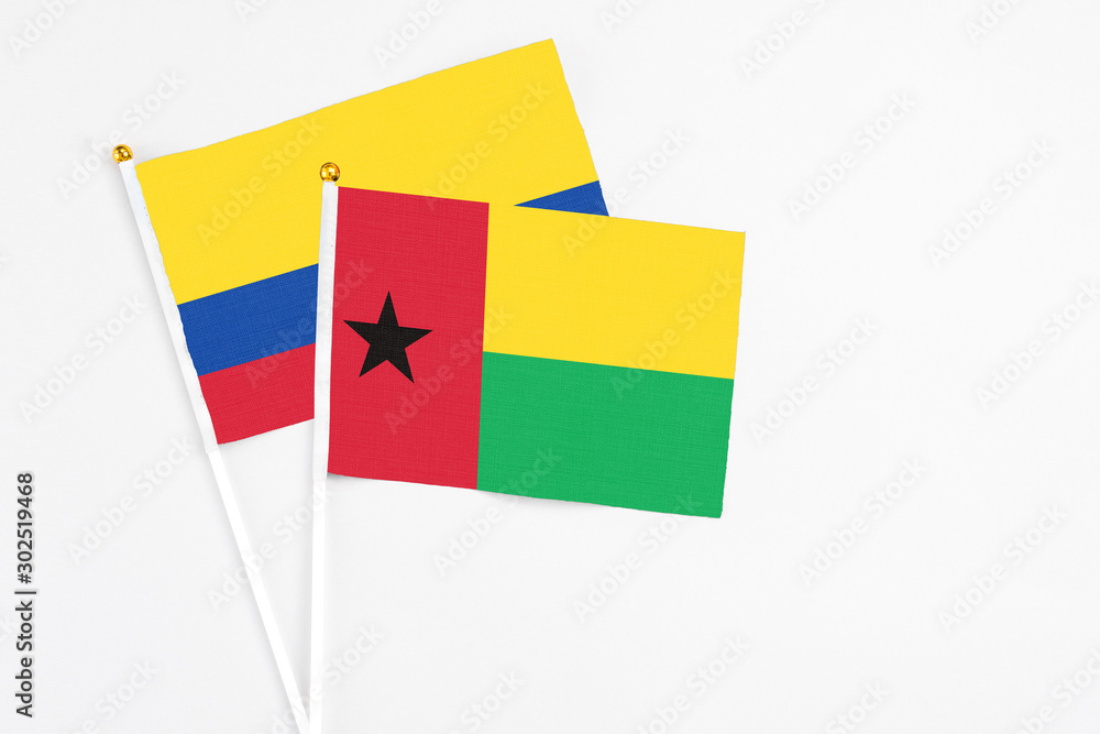 Guinea Bissau and Colombia stick flags on white background. High quality fabric, miniature national flag. Peaceful global concept.White floor for copy space. Guinea Bissau and Colombia stick flags on white background. High quality fabric, miniature national flag. Peaceful global concept.White floor for copy space.