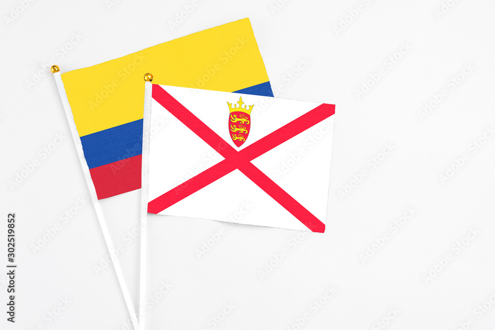 Jersey and Colombia stick flags on white background. High quality fabric, miniature national flag. Peaceful global concept.White floor for copy space. Jersey and Colombia stick flags on white background. High quality fabric, miniature national flag. Peaceful global concept.White floor for copy space.
