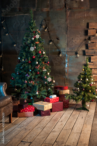 Winter home decor. Christmas tree in the interior against a wooden wall.