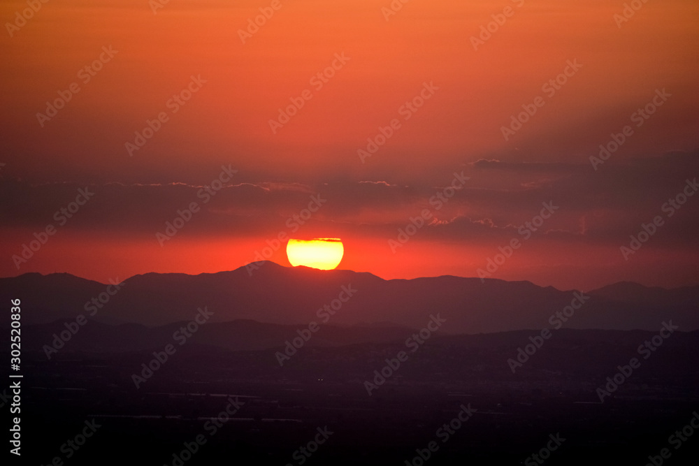 the reddish sun behind the mountains the reddish sun behind the mountains