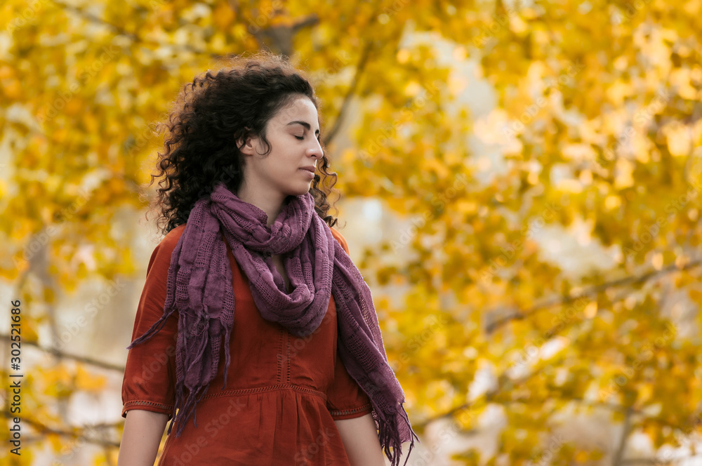 Young woman, dressed in casual clothes, with relaxed attitude, in a forest with autumn colors. Young woman, dressed in casual clothes, with relaxed attitude, in a forest with autumn colors.