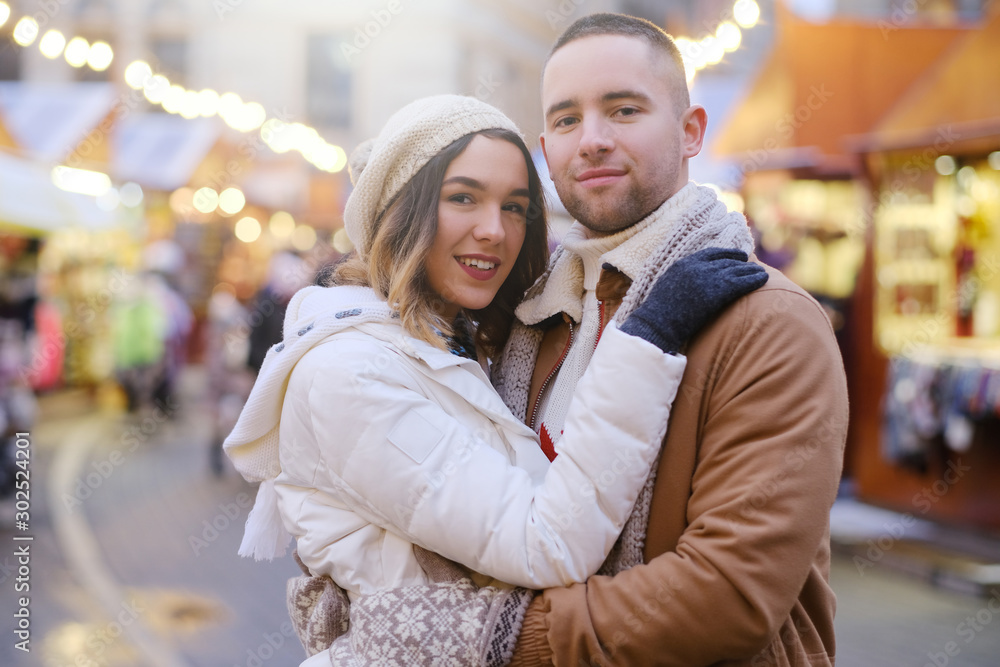 Beautiful romantic couple enjoy their Christmas day on traditional festive market. Beautiful romantic couple enjoy their Christmas day on traditional festive market.