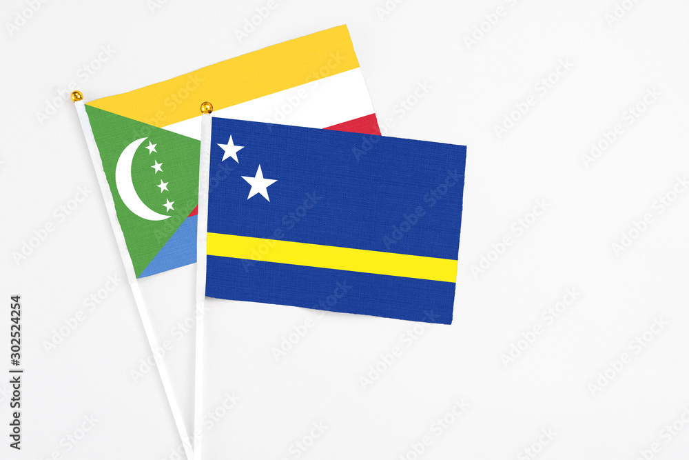 Curacao and Comoros stick flags on white background. High quality fabric, miniature national flag. Peaceful global concept.White floor for copy space. Curacao and Comoros stick flags on white background. High quality fabric, miniature national flag. Peaceful global concept.White floor for copy space.