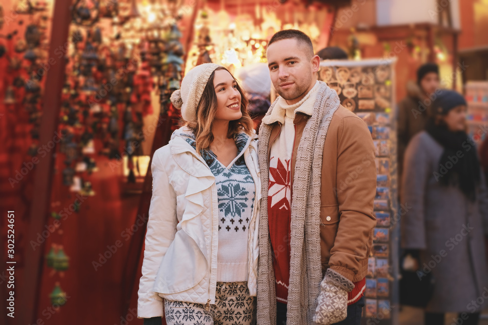 At traditional festive market attractive couple enjoy Christmas day while have a date.