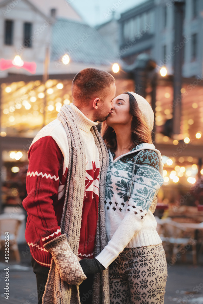 Φωτογραφία Lovely couple are kissing on the street while have a date on Christmas day