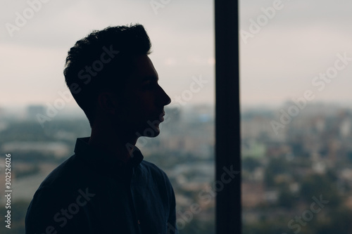 Young male profile portrait against window