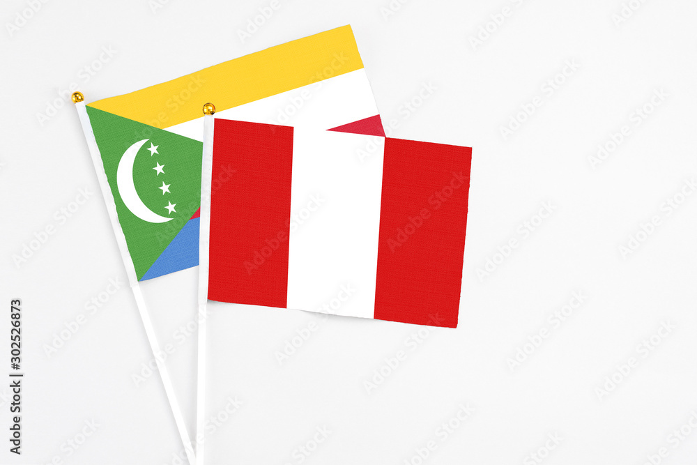 Peru and Comoros stick flags on white background. High quality fabric, miniature national flag. Peaceful global concept.White floor for copy space. Peru and Comoros stick flags on white background. High quality fabric, miniature national flag. Peaceful global concept.White floor for copy space.