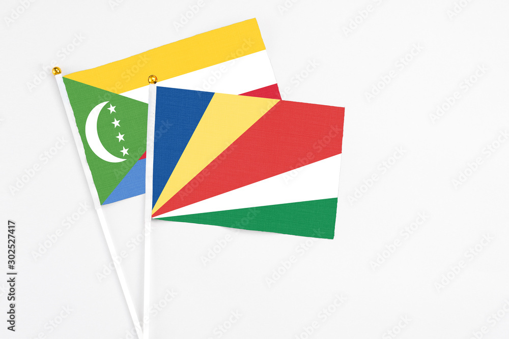 Seychelles and Comoros stick flags on white background. High quality fabric, miniature national flag. Peaceful global concept.White floor for copy space. Seychelles and Comoros stick flags on white background. High quality fabric, miniature national flag. Peaceful global concept.White floor for copy space.