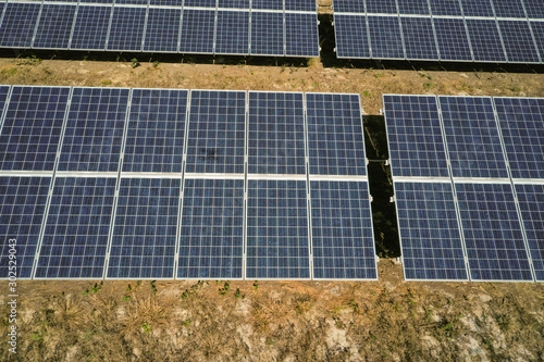 Aerial view of a solar farm. Multiple rows of solar panels in a line.