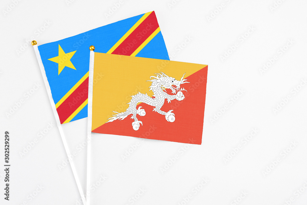Bhutan and Congo stick flags on white background. High quality fabric, miniature national flag. Peaceful global concept.White floor for copy space. Bhutan and Congo stick flags on white background. High quality fabric, miniature national flag. Peaceful global concept.White floor for copy space.