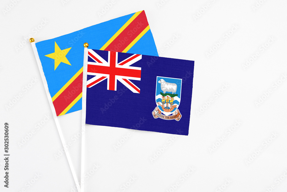 Fototapeta premium Falkland Islands and Congo stick flags on white background. High quality fabric, miniature national flag. Peaceful global concept.White floor for copy space.