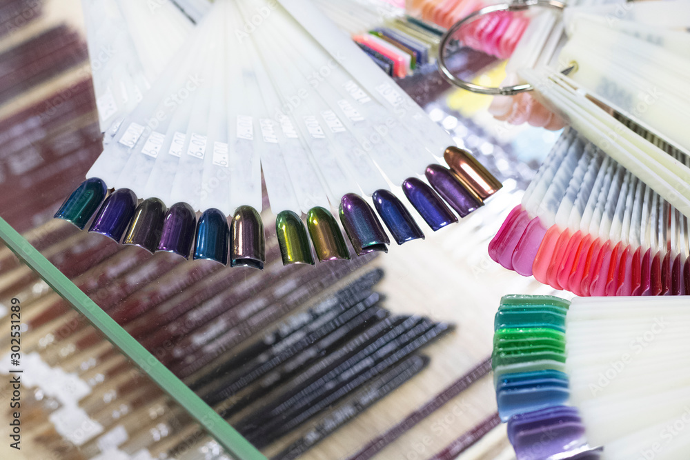 Multicolored nail polish on artificial plastic nails - obrazy, fototapety, plakaty 