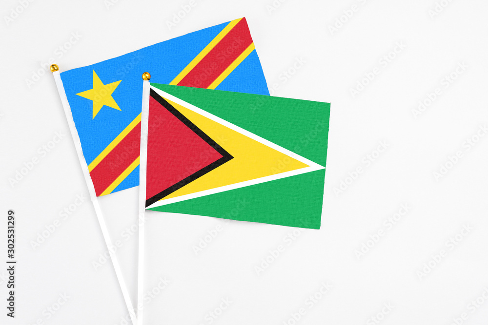 Guyana and Congo stick flags on white background. High quality fabric, miniature national flag. Peaceful global concept.White floor for copy space. Guyana and Congo stick flags on white background. High quality fabric, miniature national flag. Peaceful global concept.White floor for copy space.