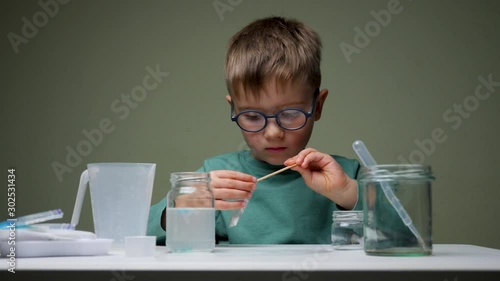 Alternative education. Boy playing indoor. Chemistry for beginners. Home laboratory with young chemist. Kid doing experiments.Leisure activity indoors. Child playing with reagents photo