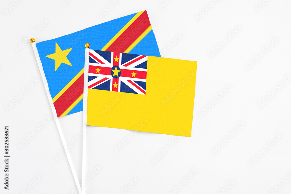 Niue and Congo stick flags on white background. High quality fabric, miniature national flag. Peaceful global concept.White floor for copy space. Niue and Congo stick flags on white background. High quality fabric, miniature national flag. Peaceful global concept.White floor for copy space.