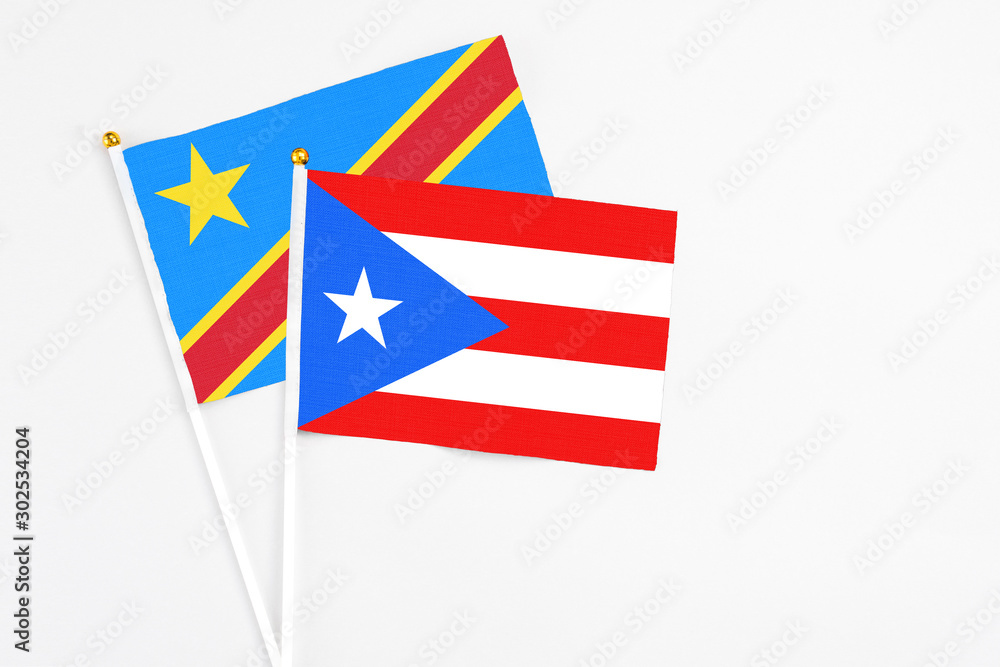 Puerto Rico and Congo stick flags on white background. High quality fabric, miniature national flag. Peaceful global concept.White floor for copy space. Puerto Rico and Congo stick flags on white background. High quality fabric, miniature national flag. Peaceful global concept.White floor for copy space.