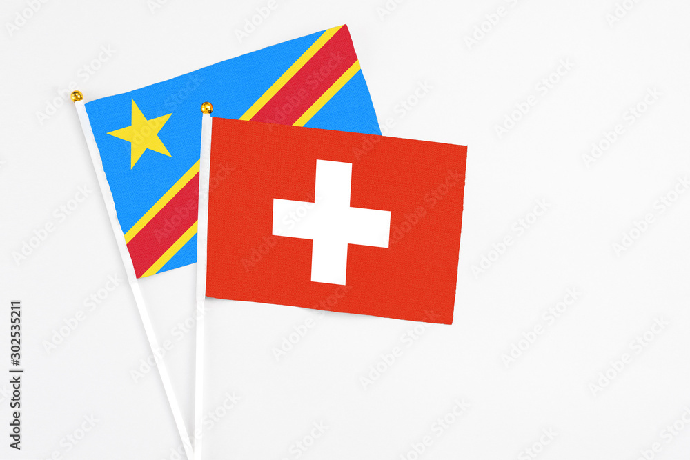 Switzerland and Congo stick flags on white background. High quality fabric, miniature national flag. Peaceful global concept.White floor for copy space.